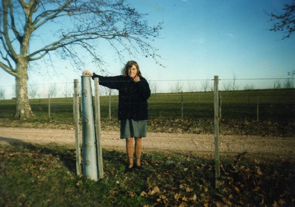 Olga Hughes de Hughes, junto a un poste del primer alambrado, Estancia 