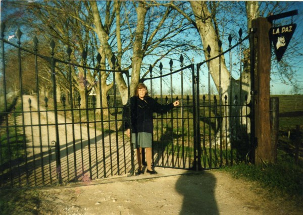 Olga Hughes de Hughes en el portón de acceso en su actual emplazamiento desde 1958